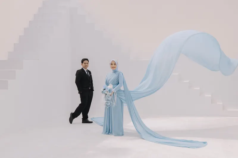 Kedua mempelai berdampingan dengan gaun biru yang menjuntai